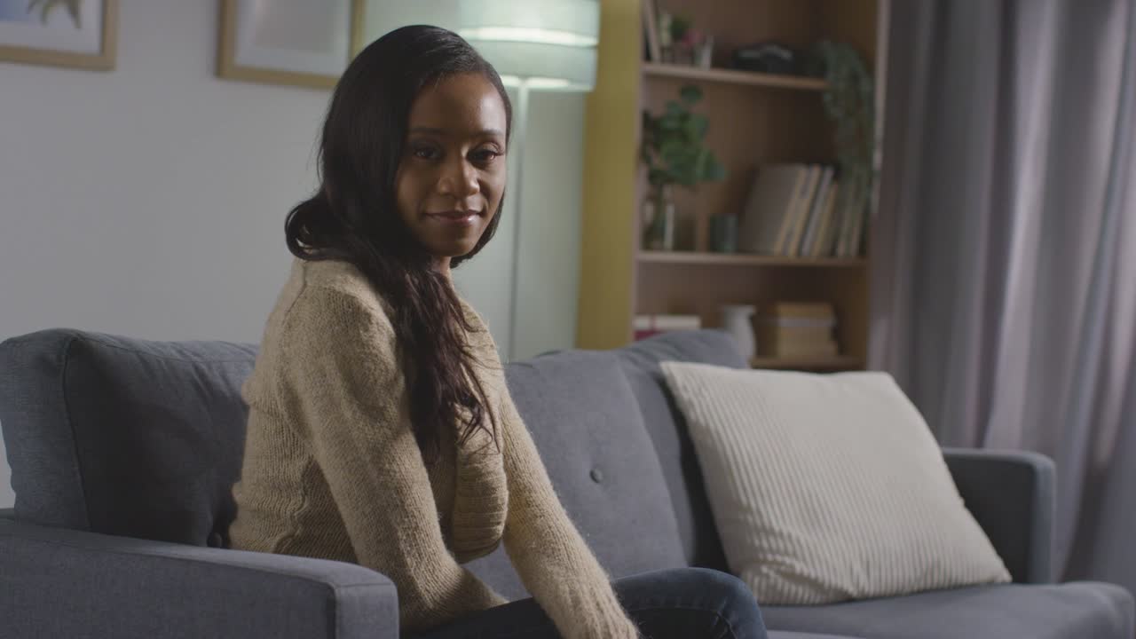 Portrait Of Smiling Young Woman Relaxing At Home Sitting On Sofa 1