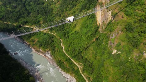 person hanging from kushma bungee jump off suspension bridge