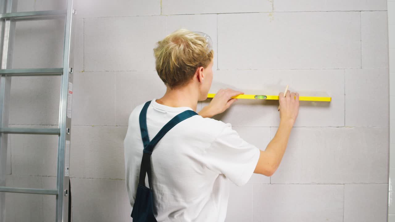 Young Construction Worker Explaining and Demonstrating with a Spirit Level