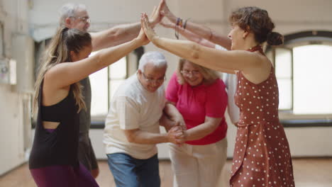 senior people playing oranges and lemons in dance studio