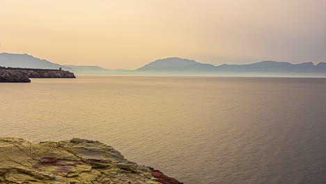 time lapse of sea waves at coast of sicily with hills in background in italy