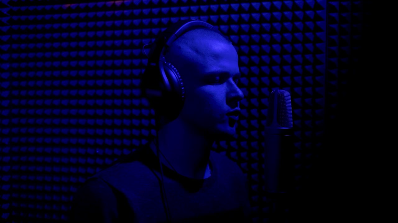 músico grabando en un estudio iluminado con azul