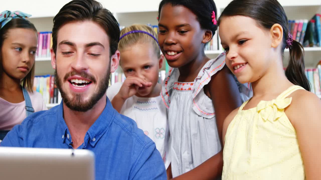 Teacher interacting with students while using digital tablet