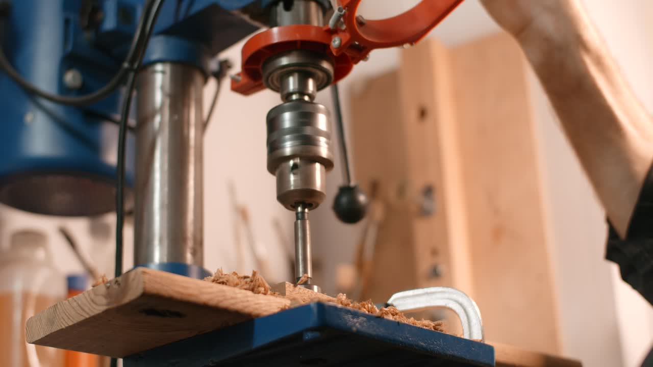 Person Using Drill Press on Wood