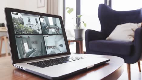 laptop on coffee table in living room with home security camera views on screens, slow motion