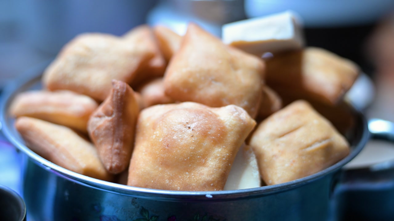 A close-up of traditional Mongolian bread, or Boortsog, a type of fried dough, served in a bowl as a staple of nomadic hospitality and cuisine.