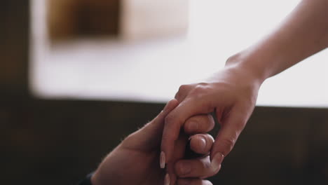 man and woman join hands on blurred background close view