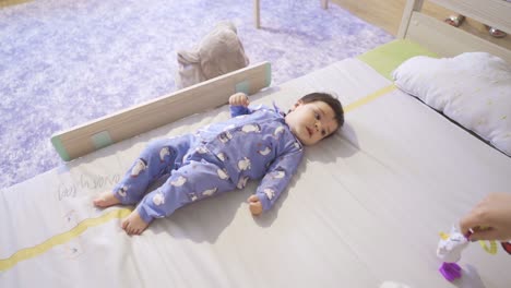 confused baby looking at toy.