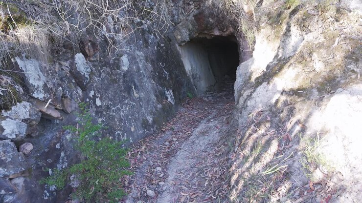 Explore the rugged entrance of an abandoned mining tunnel at Warrandyte, Melbourne. Captured in soft daylight, this scene conveys an eerie, untouched landscape perfect for adventure themes