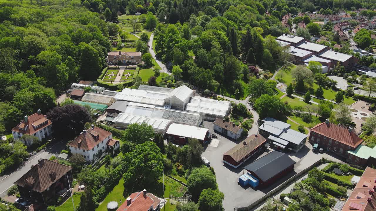 스웨덴 예테보리의 화창한 여름날 무성한 푸른 나무가 있는 보타니스카 트라드가든 근처의 주택과 건물