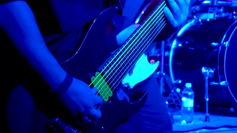 guitarist performs on an illuminated guitar onstage