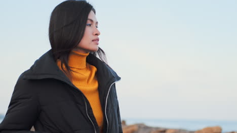 una chica asiática caminando por el mar.