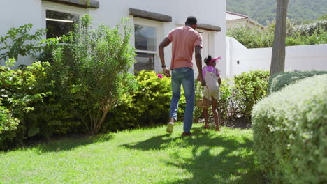 easter, african american father and daughter gardening in backyard, sunny diverse family time
