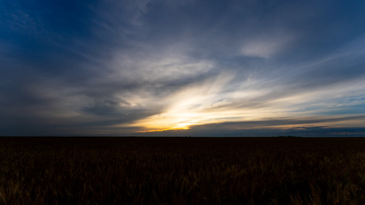 Sunset time lapse over gently swaying wheat field