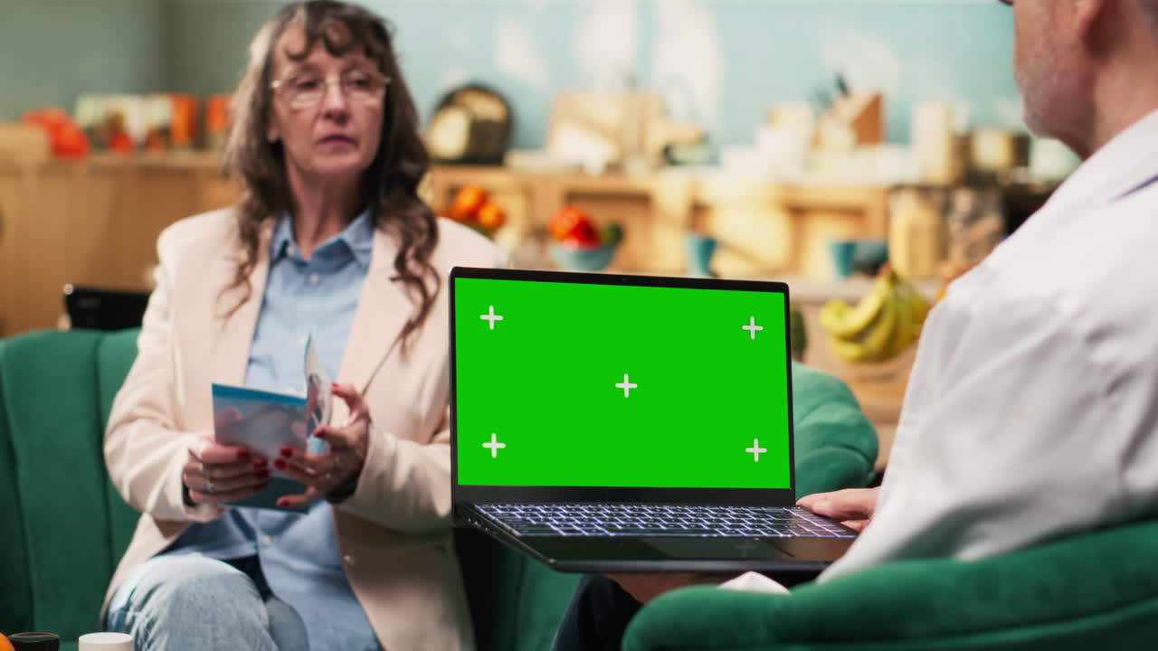 Visualizzazione di mockup su laptop tenuto in mano da un medico senior durante i servizi di assistenza domiciliare