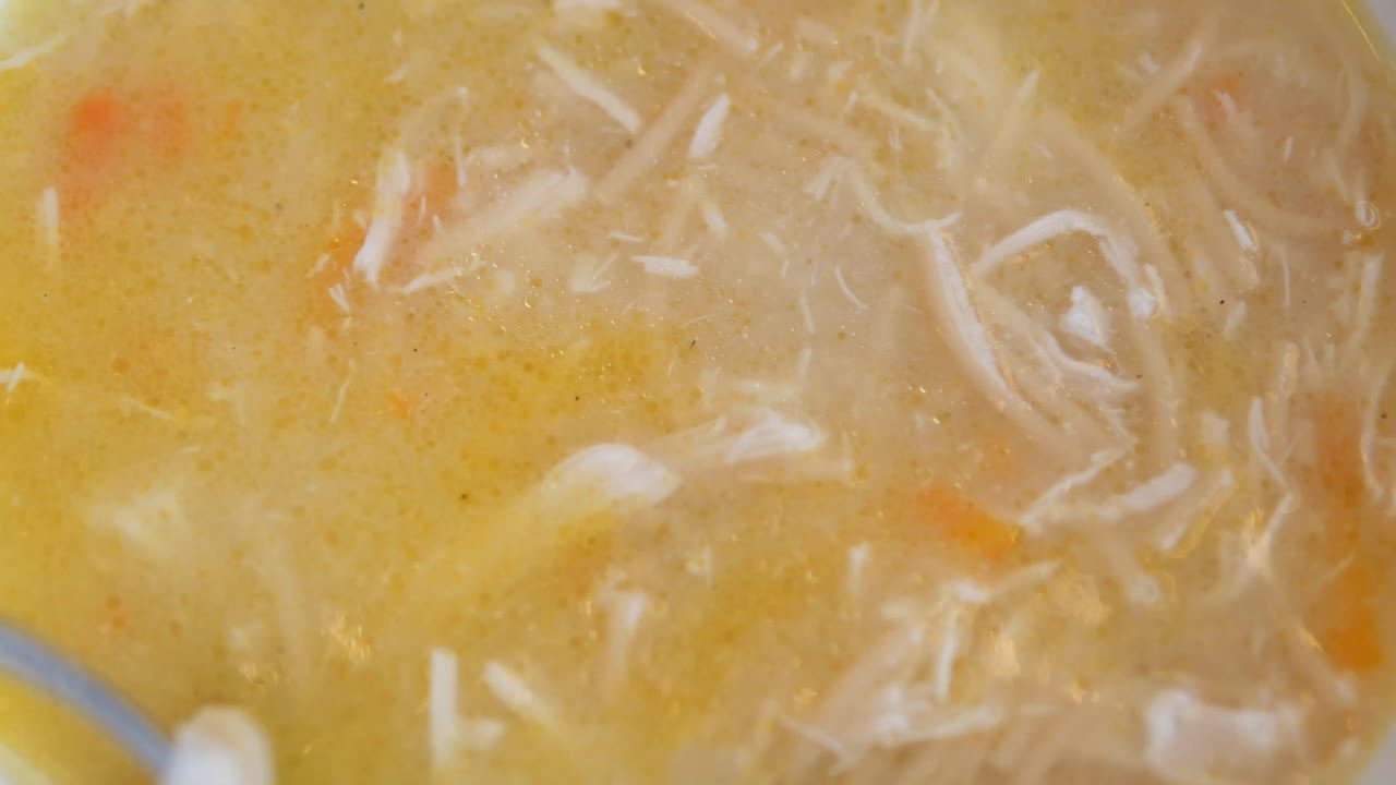 Close-Up of Hot Chicken Noodle Soup Being Stirred