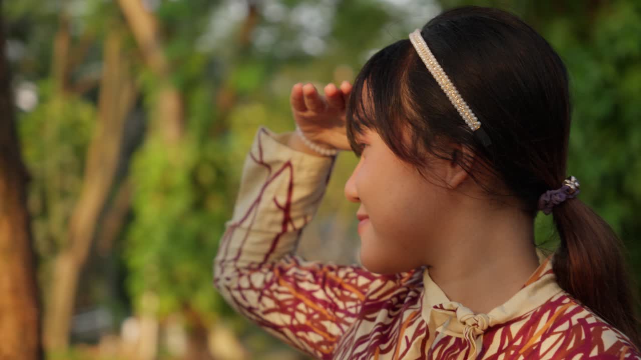 Young Asian Girl Looking into the Distance in a Park