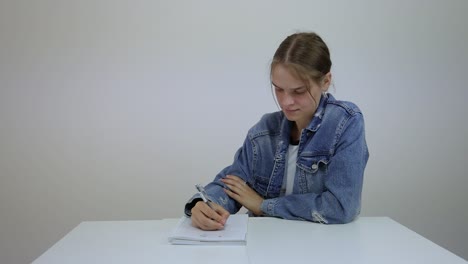 frustrated young female student throw the notebook from the table