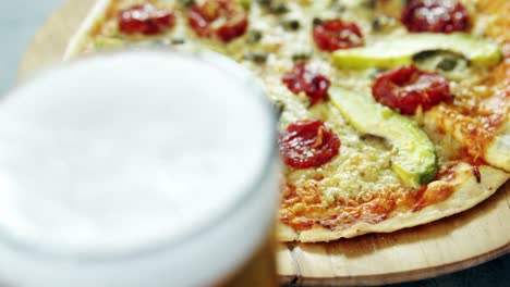una deliciosa pizza con un vaso de cerveza