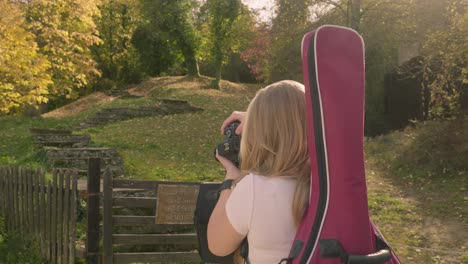 Blonde-Musikerin-Fotografiert-Herbstliche-Farbszene-Und-Lächelt-In-Die-Kamera