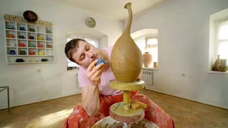 pottery artist shaping a vase on a wheel