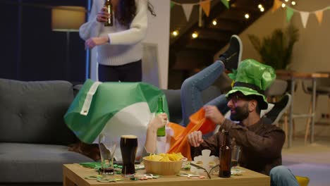 group of friends at home or in bar dressing up celebrating at st patrick's day party drinking alcohol and having fun dancing 1