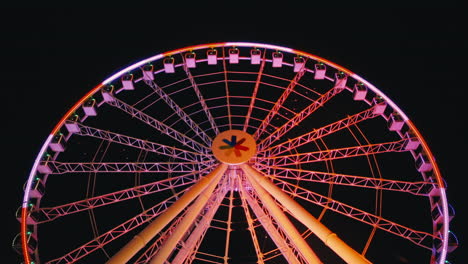 closeup of colorful spinning ferris wheel against night sky