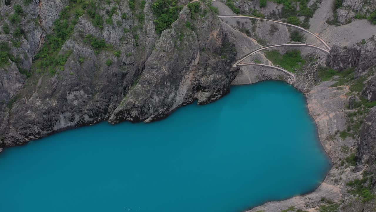 Aerial flyover above vibrant Blue Lake, on outskirts of Imotski, Croatia