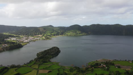 vista aérea viajando en el lago que se encuentra en la caldera del volcán y cerca de la ciudad de sete cidades en las azores, isla de sao miguel