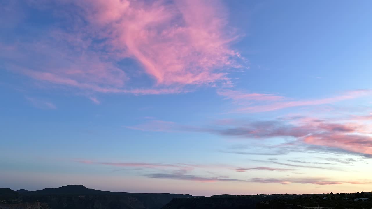Un hyperlapse cinematografico 4K con drone cattura i colori vibranti del tramonto che cambiano sopra un pittoresco canyon montano del sud-ovest. La luce serale che evolve crea uno sfondo naturale mozzafiato.