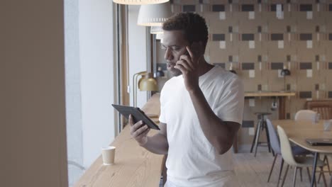 serious african american young man talking on mobile phone