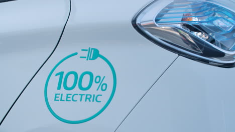 the text 100 percent electric on the white metal sheet of a car