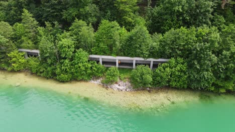 Hidden cycling tunnel snakes through forest, crystal Attersee water in Austria