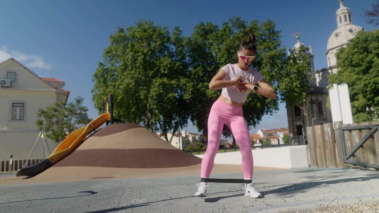 mujer haciendo ejercicio de piernas con banda de resistencia en un parque