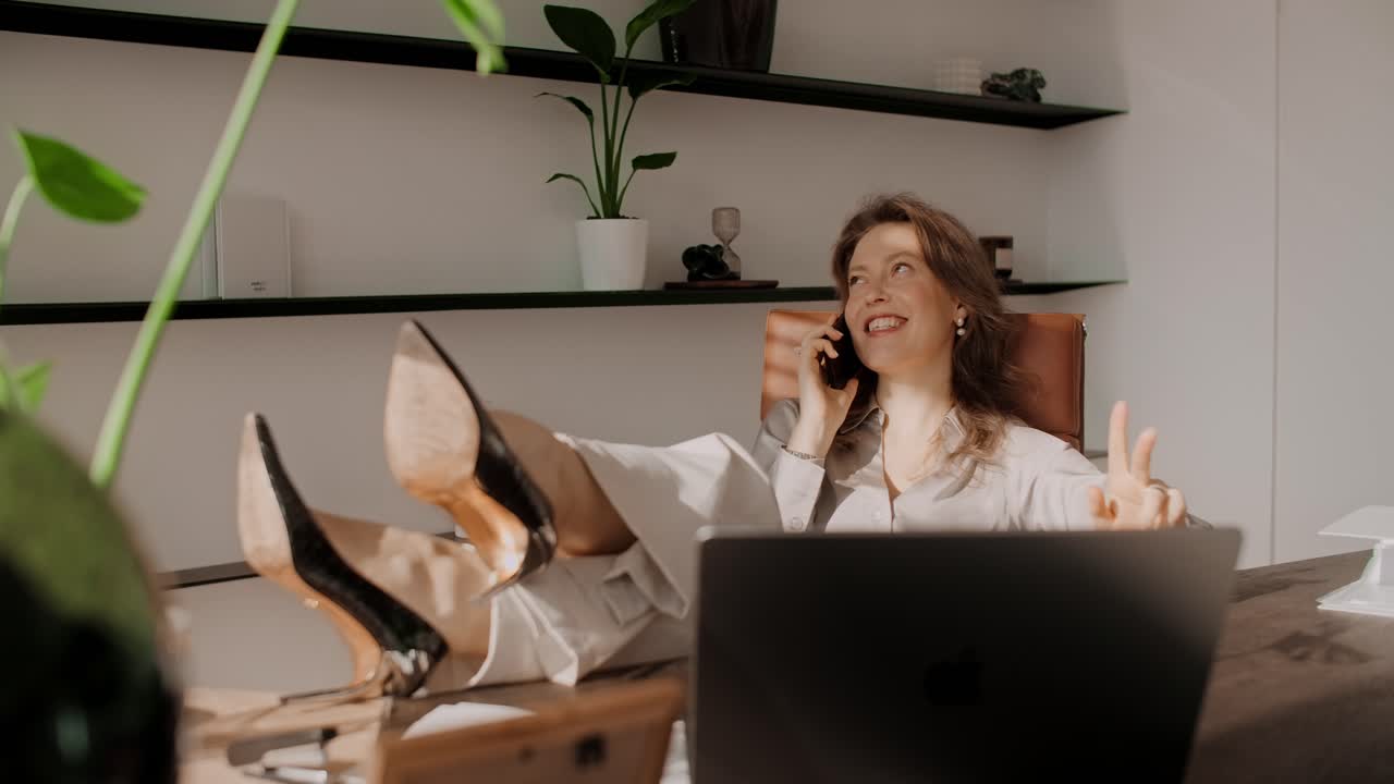 Kvinde slapper af på sit kontor under et telefonopkald