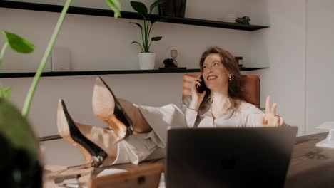 woman relaxing in her office on a phone call
