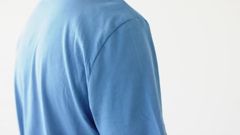 midsection of african american man wearing blue t-shirt with copy space on white background