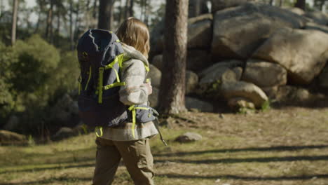 young woman backpacker hiking in the forest on a sunny day