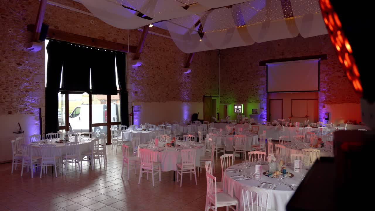 Slow motion revealing shot of a wedding hall with set tables for a banquet