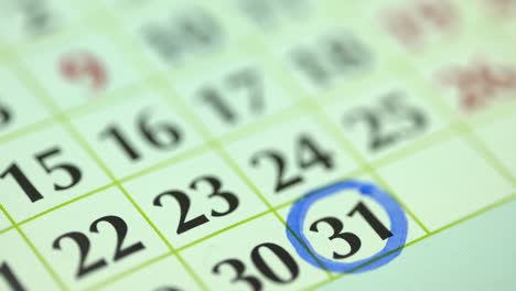 31st – thirty-first day of the month. the woman marks the calendar date with a blue marker. business wall calendar planner and organizer