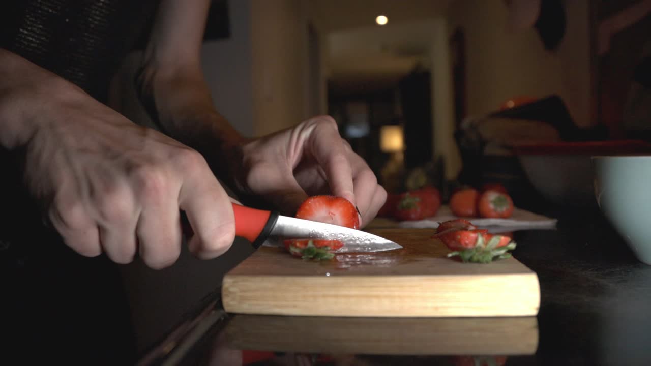 Slicing Strawberry Using Kitchen Knife On A Wooden Chopping Board. - close up shot