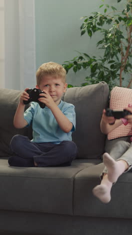 excited younger brother and elder sister feel happy after winning video game. emotional children get up from sofa jumping and lifting gaming consoles