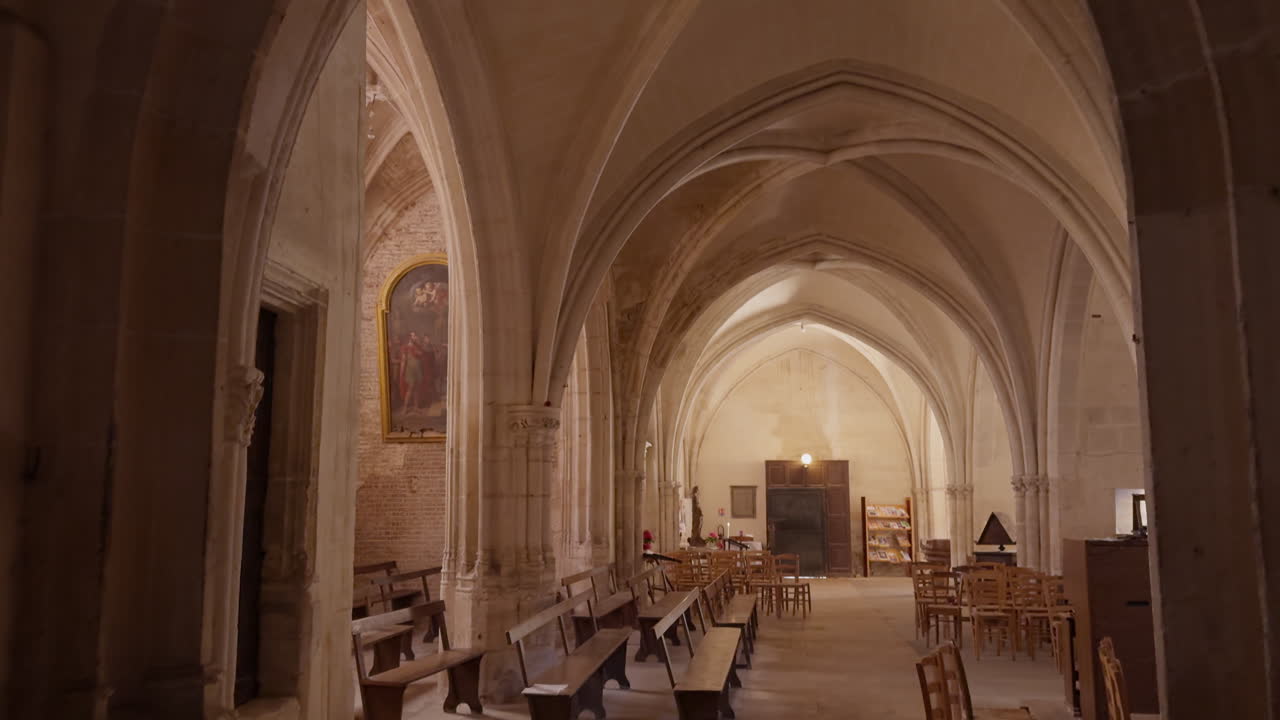 Inside view of Saint-Fargeau Church with wooden benches and chairs in France. high arched ceilings