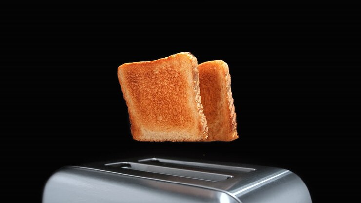 Two Golden Toasted Slices Of Sandwich Bread Popping Out Of A Chromed Toaster in Slow Motion