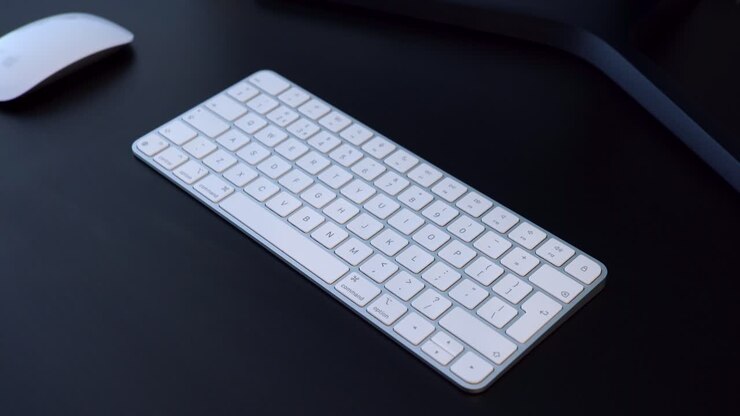 Male hands typing on a white wireless keyboard