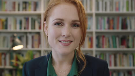 portrait of attractive young red head business woman intern smiling happy enjoying professional career opportunity in library background