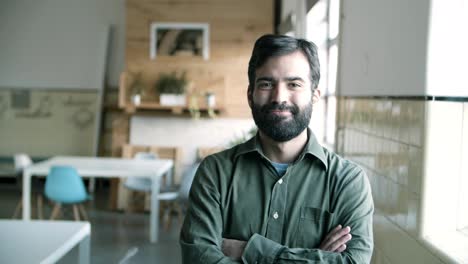 cheerful hispanic young man with crossed arms