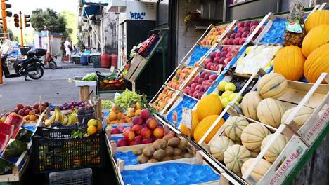 puesto de frutas en una esquina de una calle ocupada