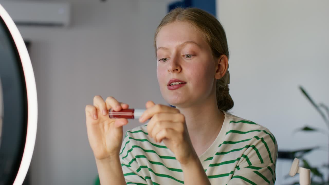 mujer joven aplicando lápiz labial rojo