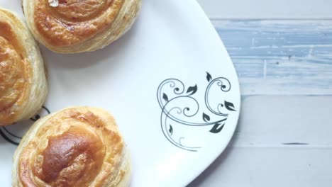 hand reaching for a pastry on a plate